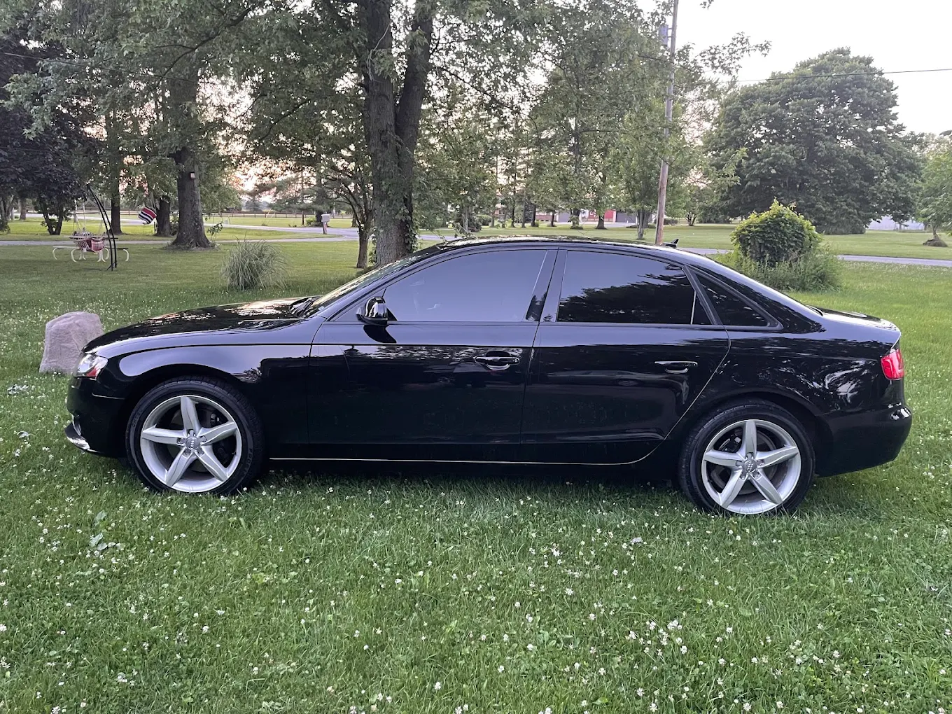Black sedan parked on grass